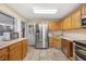 Bright kitchen with stainless steel appliances and wooden cabinets at 6895 E 74Th Ave, Commerce City, CO 80022