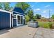 Backyard features a modern blue shed, patio, hot tub, green lawn and wood fence at 1390 Emporia St, Aurora, CO 80010