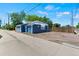 Side exterior of a blue building with a gravel parking area, door, and wood fence at 1390 Emporia St, Aurora, CO 80010