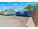 Blue single-story home featuring a gravel yard and a detached garage on a sunny day at 1390 Emporia St, Aurora, CO 80010