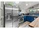 Well-lit kitchen with stainless steel appliances, blue cabinets, and open shelving at 1390 Emporia St, Aurora, CO 80010