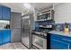 Bright kitchen with stainless steel appliances, blue cabinets, and unique backsplash at 1390 Emporia St, Aurora, CO 80010