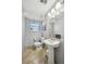 A simple bathroom with pedestal sink, a window, tile flooring, new fixtures, and a modern feel at 12931 E 46Th Ave, Denver, CO 80239
