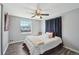 Cozy bedroom with dark plank flooring, large window, and a comfortable bed with stylish bedding at 12931 E 46Th Ave, Denver, CO 80239