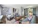 Spacious living room with modern furnishings, lots of natural light, and open access to the dining area and staircase at 12931 E 46Th Ave, Denver, CO 80239