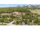 Scenic aerial view of a mountain community nestled among trees and mountains with snow-capped peaks at 876 Broken Lance Dr, Breckenridge, CO 80424