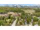 Stunning aerial view of mountain homes surrounded by lush green trees, with snow-covered mountains in the backdrop at 876 Broken Lance Dr, Breckenridge, CO 80424