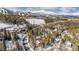 Aerial winter scene featuring several homes surrounded by snow-covered trees, with a mountain backdrop at 876 Broken Lance Dr, Breckenridge, CO 80424