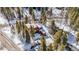 Aerial of multi-unit residence with snow-covered roofs, surrounded by evergreens at 876 Broken Lance Dr, Breckenridge, CO 80424