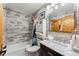 Updated bathroom with stylish gray tiled walls, marble countertop, and a shower with a curtain at 876 Broken Lance Dr, Breckenridge, CO 80424