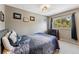 Cozy bedroom with a blue patterned comforter, neutral walls, and a view of the trees at 876 Broken Lance Dr, Breckenridge, CO 80424