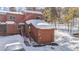 Exterior view of a multi-level townhouse with a snow-covered roof, stairs to the front entrance, and a one-car garage at 876 Broken Lance Dr, Breckenridge, CO 80424