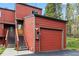 Red exterior showcasing a garage and stairway leading to the front door at 876 Broken Lance Dr, Breckenridge, CO 80424
