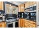Close up of stainless steel oven and cooktop, light wooden cabinets, and black countertop at 876 Broken Lance Dr, Breckenridge, CO 80424