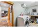 Laundry room with white washer and dryer, wood trim, and a glimpse of a bedroom at 876 Broken Lance Dr, Breckenridge, CO 80424