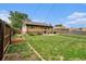 Expansive backyard with lush green grass, garden beds, and mature trees, creating a serene outdoor space at 7625 Turner Dr, Denver, CO 80221