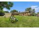 Spacious backyard featuring a lush lawn, play set, and mature trees, perfect for outdoor activities and relaxation at 7625 Turner Dr, Denver, CO 80221