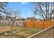 Fenced backyard with grass and trees, with commercial buildings in the background at 195 S Sable Blvd # U12, Aurora, CO 80012