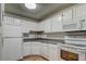 Bright kitchen with white cabinets, granite countertops, and appliances at 195 S Sable Blvd # U12, Aurora, CO 80012