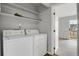Laundry room with washer, dryer, shelving and an open door to an adjacent room at 195 S Sable Blvd # U12, Aurora, CO 80012