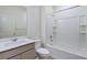 A full bathroom with a shower and tub combination and gray cabinets at 9882 Cathay St, Commerce City, CO 80022