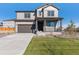 Charming two-story home featuring a covered porch, manicured lawn, and an attached two-car garage at 9882 Cathay St, Commerce City, CO 80022