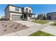 Attractive home exterior featuring a front porch, landscaped front yard with rocks, and a wide driveway at 9882 Cathay St, Commerce City, CO 80022