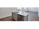 Kitchen island with a stainless steel dishwasher, sink, granite countertop, and laminate flooring at 9882 Cathay St, Commerce City, CO 80022