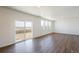 Spacious living room with sliding glass doors, large windows, and beautiful hardwood flooring at 9882 Cathay St, Commerce City, CO 80022