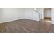 Bright, open living area with hardwood floors and white walls, leading to staircase and entrance at 9882 Cathay St, Commerce City, CO 80022