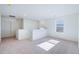 An empty loft with neutral colored carpet, white walls and trim, and a large window at 9882 Cathay St, Commerce City, CO 80022