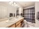 A well-lit bathroom features coordinated decor, sink, and shower with a decorative curtain at 13255 Holly St # B, Thornton, CO 80241