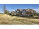 Exterior view of brown and blue townhomes, with well-maintained lawns and mature trees in the distance at 13255 Holly St # B, Thornton, CO 80241