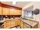Bright kitchen features stainless steel appliances, light wooden cabinets, and a window view of living area at 13255 Holly St # B, Thornton, CO 80241