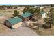 Overhead view of a house with green roofs, multiple outbuildings, a wide driveway, and mature trees at 37653 Lark Dr, Elizabeth, CO 80107