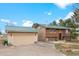 Charming home featuring a green metal roof, log siding, and an attached two-car garage at 37653 Lark Dr, Elizabeth, CO 80107
