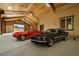 Spacious garage features two classic cars, red Corvette and black Mustang Mach 1 at 37653 Lark Dr, Elizabeth, CO 80107