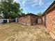 Brick home exterior and backyard with patio, grass, sheds, and mature trees on a partly cloudy day at 10440 Gilpin St, Northglenn, CO 80233