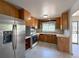 Spacious kitchen with tile floors, stainless refrigerator and wood cabinetry at 10440 Gilpin St, Northglenn, CO 80233