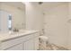 Modern bathroom with a white vanity, shower-tub combo and marble-style floors at 7321 Waterleaf Trl, Littleton, CO 80125