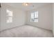 Well-lit bedroom with neutral carpet, two large windows, and fresh, white walls at 7321 Waterleaf Trl, Littleton, CO 80125