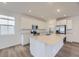 Modern kitchen with white cabinets, stainless steel appliances, and large center island at 7321 Waterleaf Trl, Littleton, CO 80125