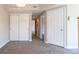 Neutral hallway featuring carpet floors and a door to the bedroom at 14300 Waterside Ln # L5, Broomfield, CO 80023