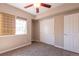 Cozy bedroom with neutral tones, plush carpet, a ceiling fan, and a window with bright light coming through at 14300 Waterside Ln # L5, Broomfield, CO 80023