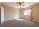 Bright bedroom featuring a ceiling fan, plush carpet, and a sunlit window with decorative curtains at 14300 Waterside Ln # L5, Broomfield, CO 80023