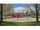 Community playground with swings, slides, and climbing structures surrounded by trees and green grass at 14300 Waterside Ln # L5, Broomfield, CO 80023