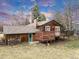 Exterior view of a wood home featuring deck, green door, and wood pile at 7284 Dry Creek Rd, Niwot, CO 80503