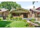 Charming brick home with a well-manicured lawn, beautiful landscaping, and a welcoming front porch at 843 Adams St, Denver, CO 80206