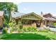 Charming brick home featuring a well-manicured lawn and lush landscaping at 843 Adams St, Denver, CO 80206