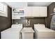 This laundry room contains a washing machine, dryer, sink, and storage cabinets at 843 Adams St, Denver, CO 80206